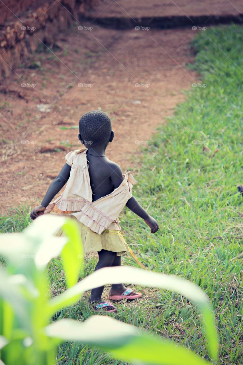 Dancing Girl . While walking through a village in Uganda this little girl told me she was "dancing to the music in my head" as we walked passed her she continued on...