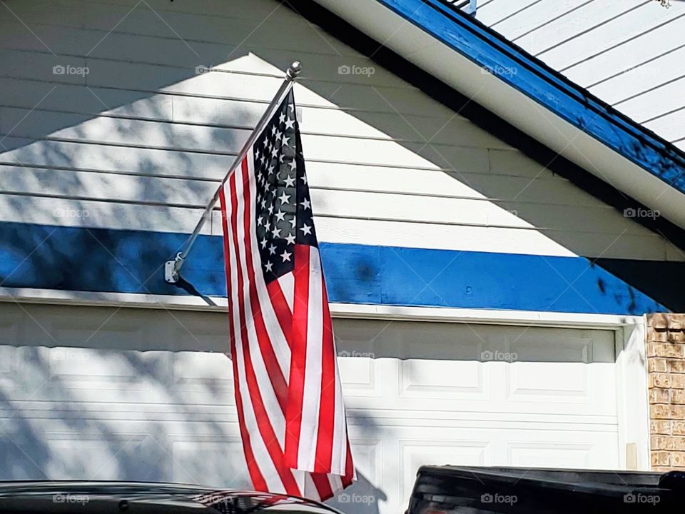 American flag on a residential white and blue home