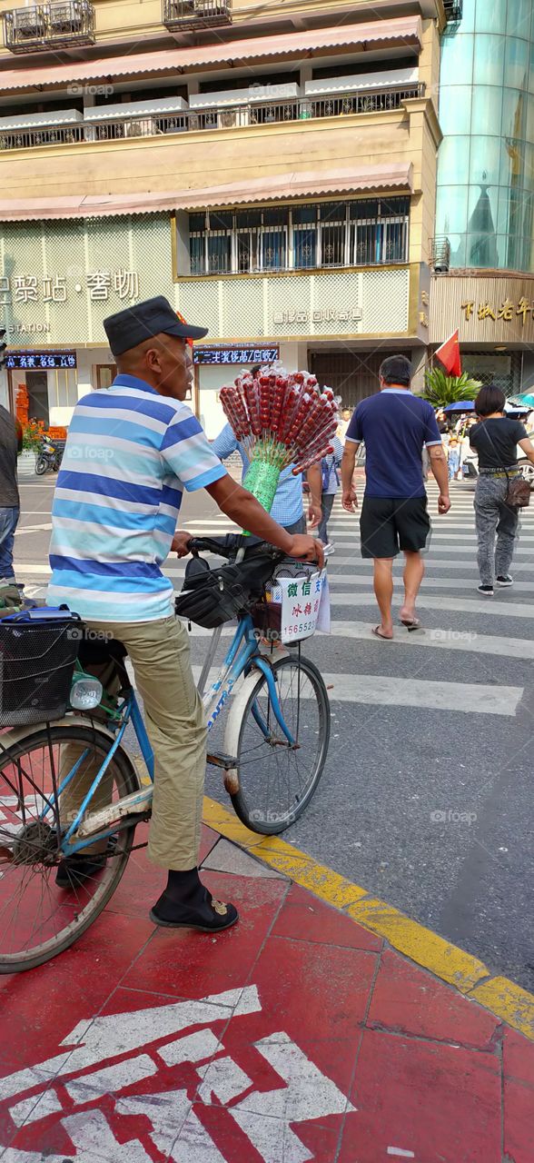 These are sugar-coated haws, or “Bingtang Hulu” in Chinese. Sugar-coated haw is a traditional snack of Beijing. As a local, you used to see peddlers selling sugar-coated haws on streets and lanes.