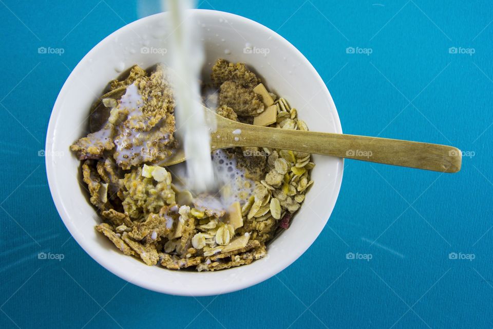 milk splashing into cereals. milk splash into full bowl of crunchy cereals