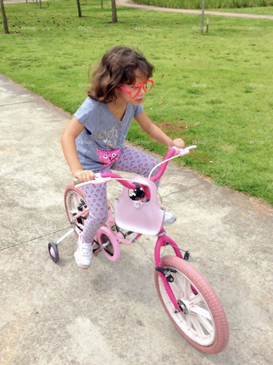 child on pink bicycle