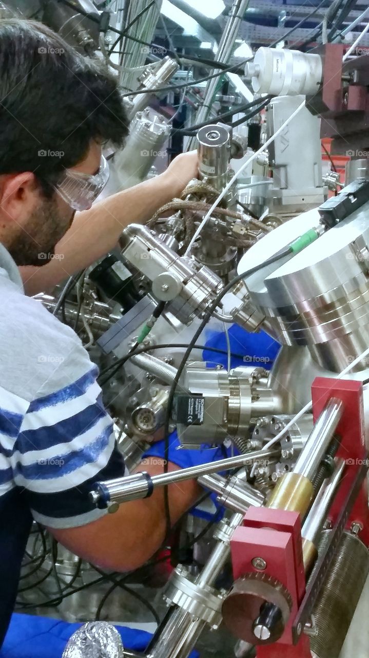 A research scientist working between complicated parts in a labratory environment