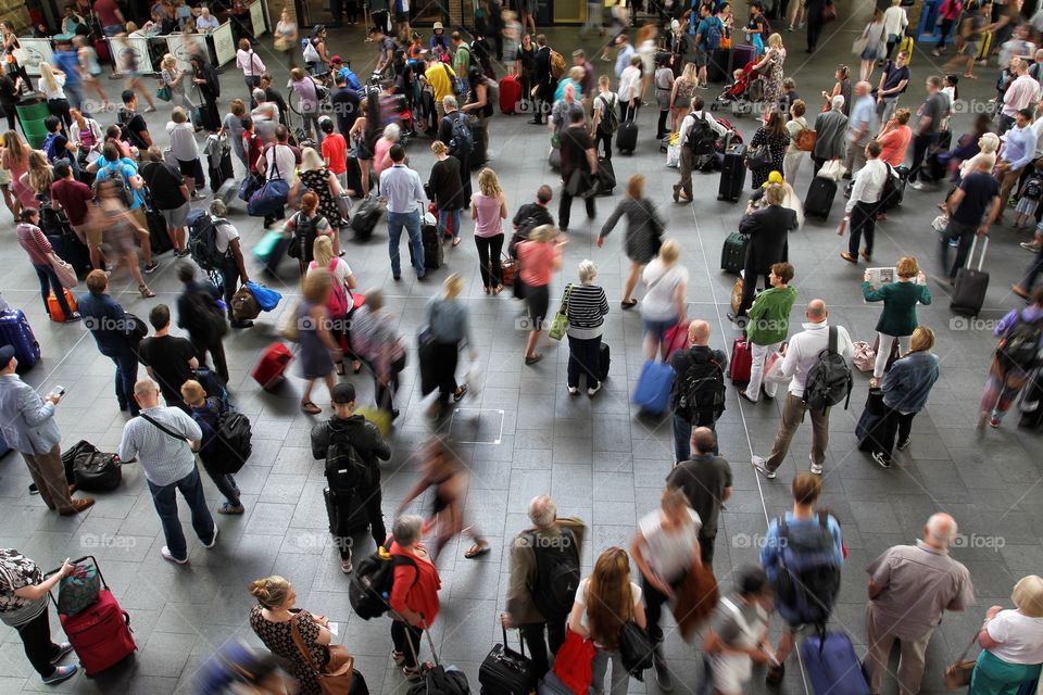 Commuters and passengers in a crowded concourse at King's Cross train station in London.