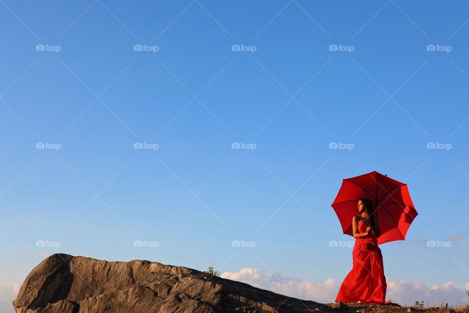 Woman in red over cliff