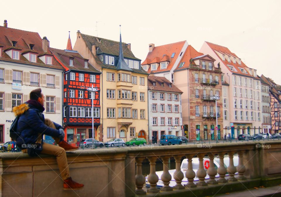 Young man sitting near building