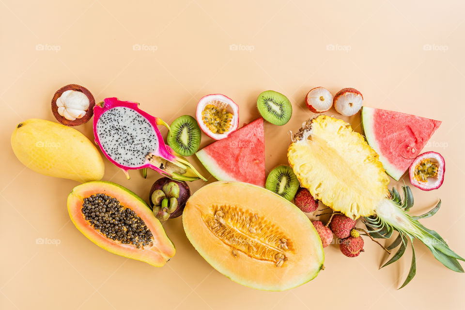 Fresh exotic fruits lying on orange background 