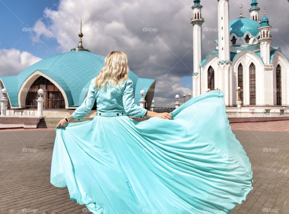 girl on the background of the mosque turquoise color