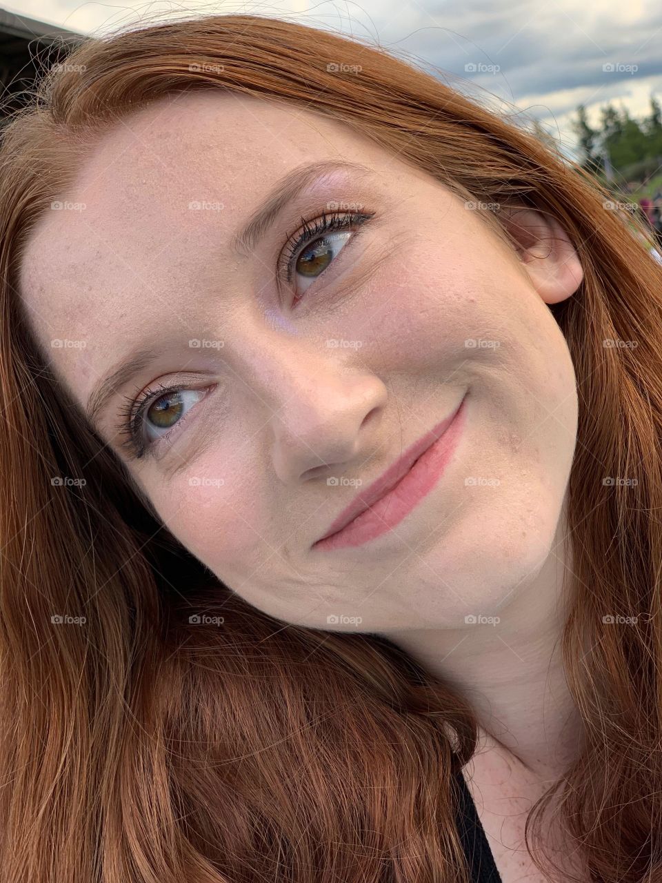 Beautiful closeup portrait of a redheaded green eyed model smiling and having fun