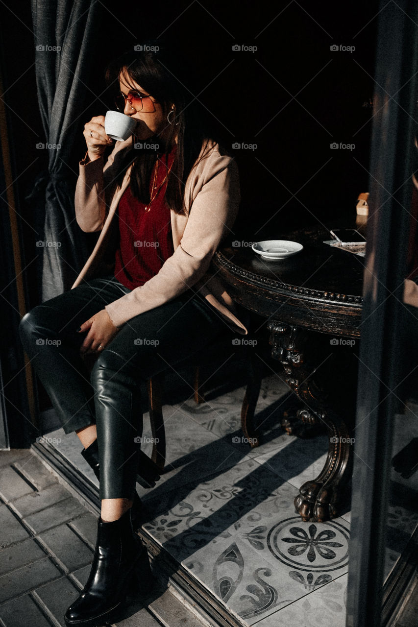 Beautiful brunette drink coffee in street cafe