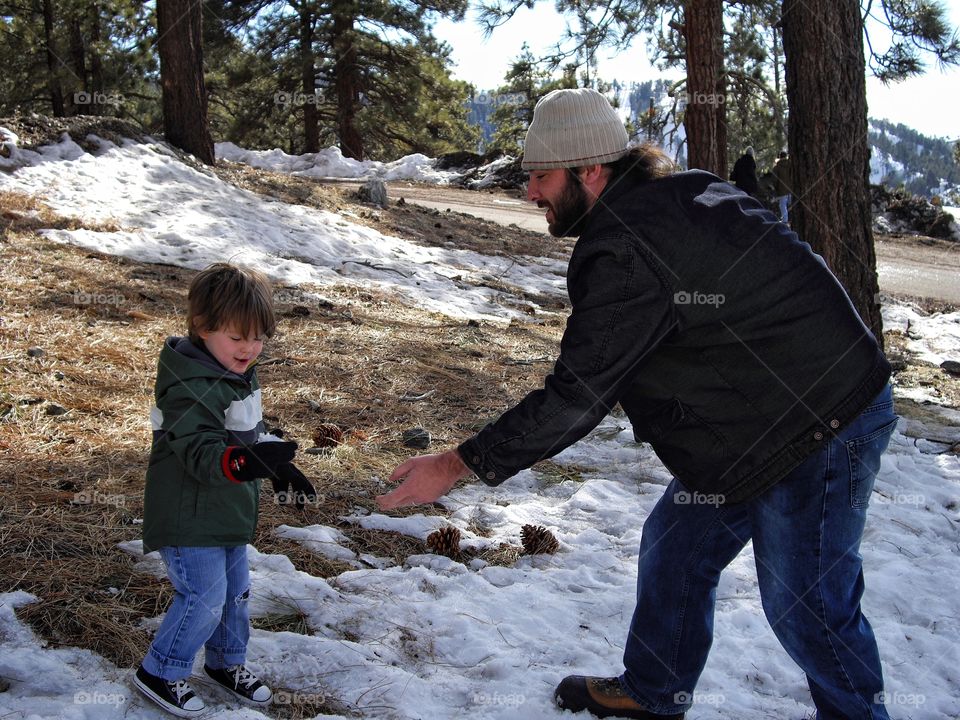 Father And Son Playing In Snow On Christmas 