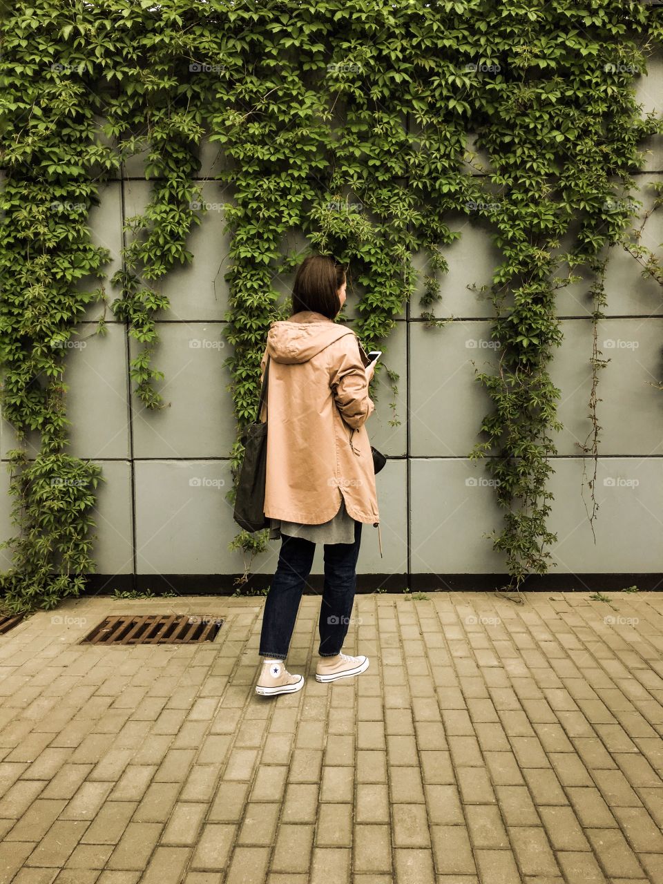 Rear view of a woman with mobile phone in hand