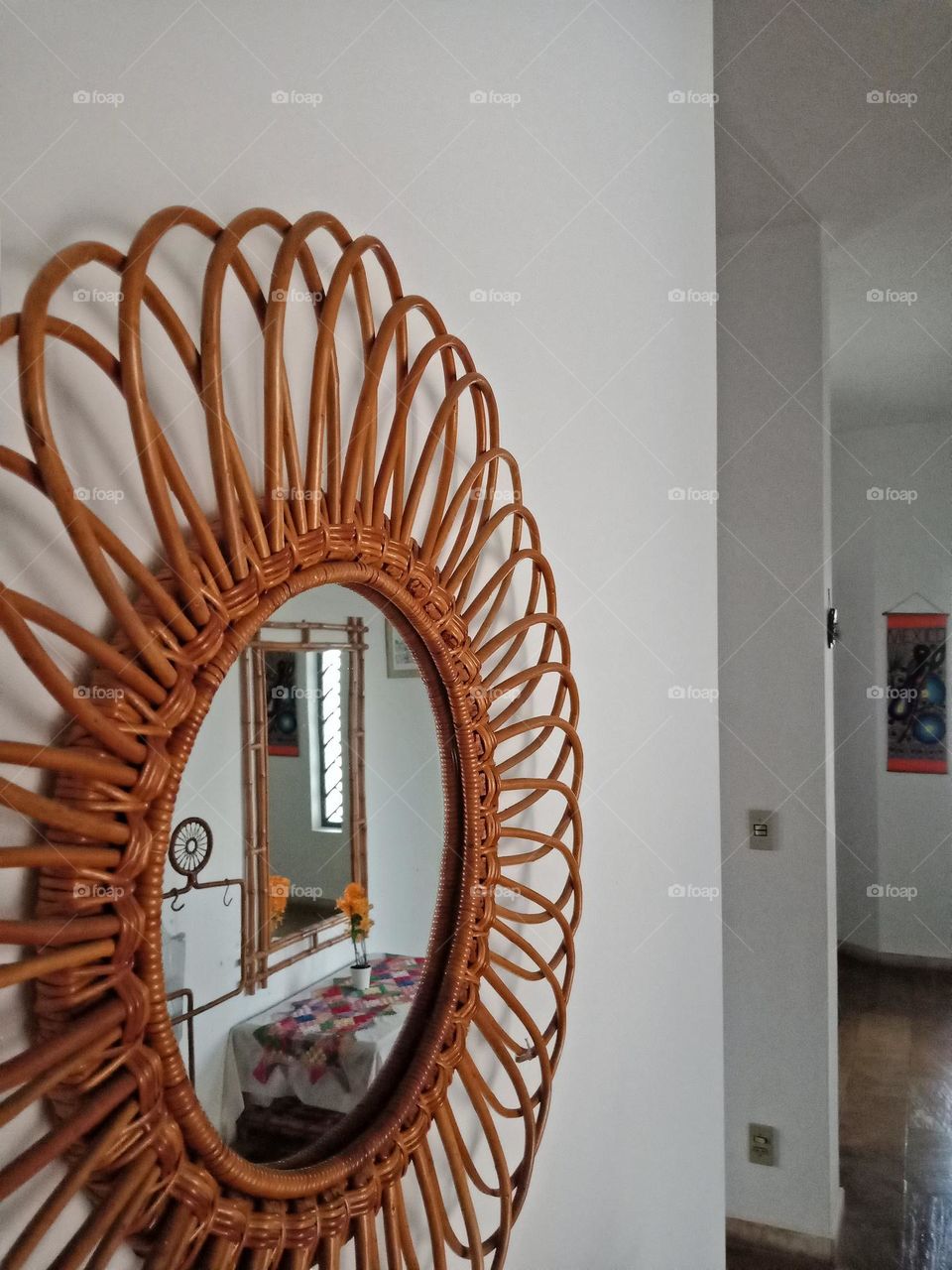 A rectangular mirror in a round mirror at a hall.