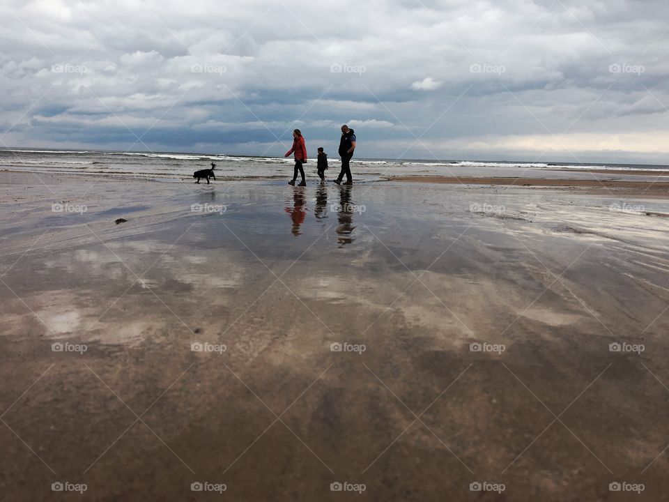 Family walking the dog on Saltburn beach when the tide is out ... 