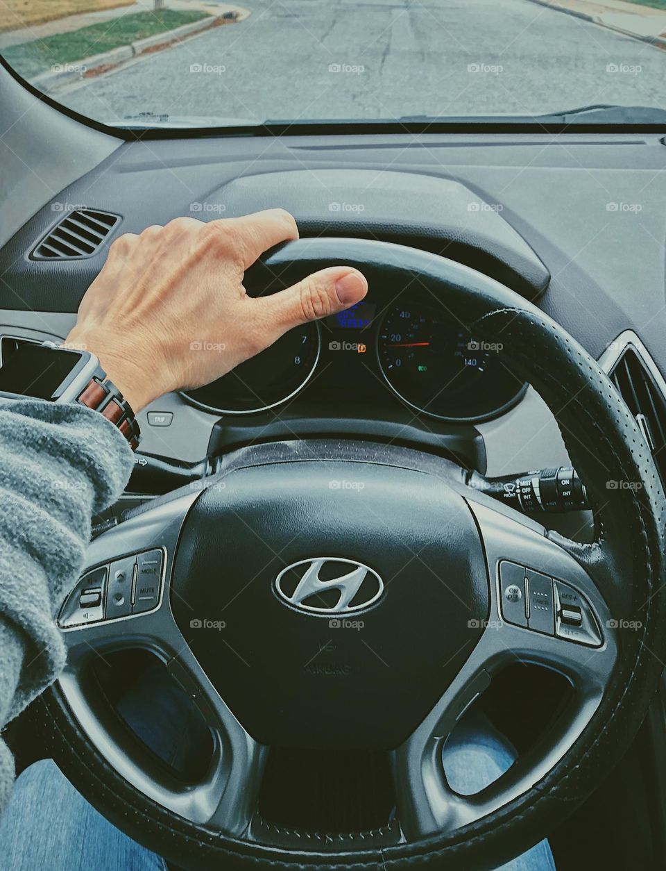 Woman’s hand on steering wheel, driver’s perspective, driving a Hyundai Tucson, driving to work, commuting to work in a car, behind the steering wheel