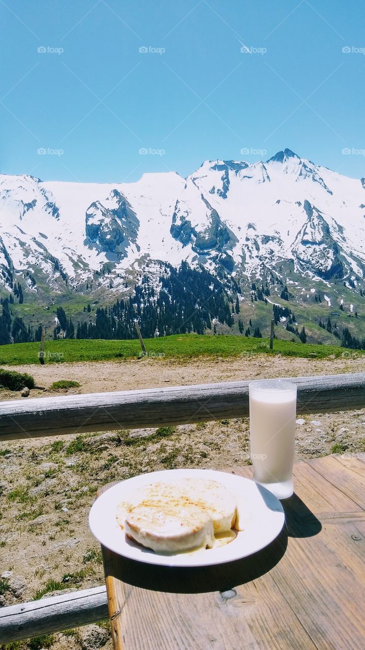 Atop Maria Rickenbach mountain in the Switzerland alps drinking fresh milk and this bread/cheese thing. Forgot the name