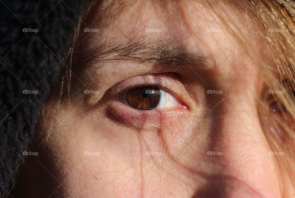 Shadow Scars; Closeup of woman’s eye(Brown) with strands of hair creating a shadow across her eye.