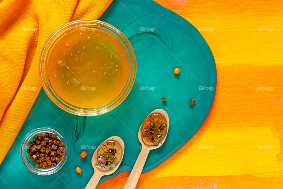 Concept of healthy ecological food. Products with a large number of vitamins that increase the immune system. Honey, pollen and berries of sea buckthorn on a background of contrasting colour. Food photos, top view, copy space