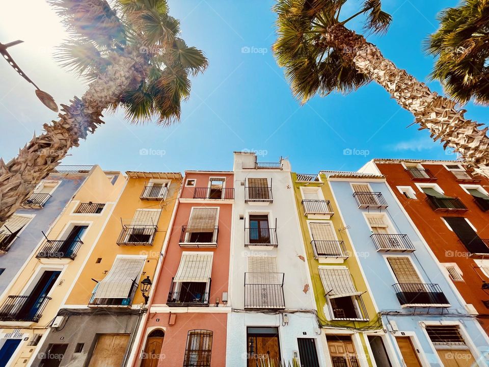 Low angle view of colored house in La Vila Joiosa, Alicante, Spain, colorful buildings with palms 