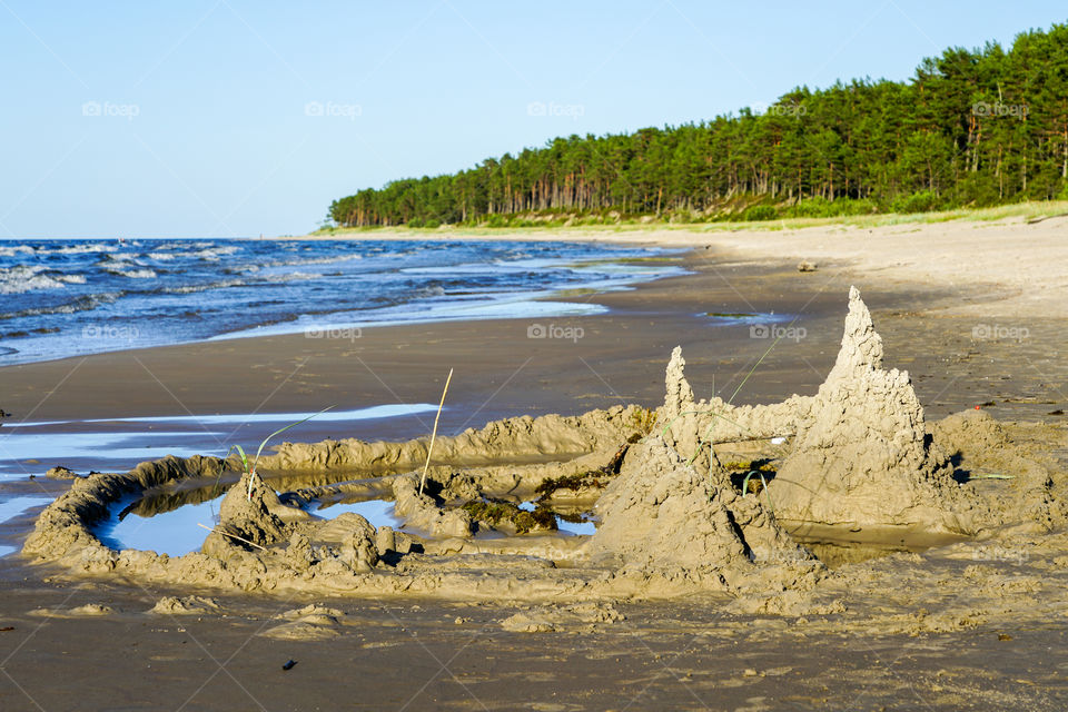 a child built a sand castle on the seashore