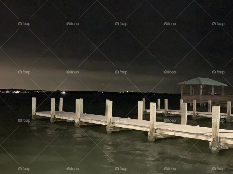 Boat floating docks on the Indian lagoon river in central eastern Florida at night.