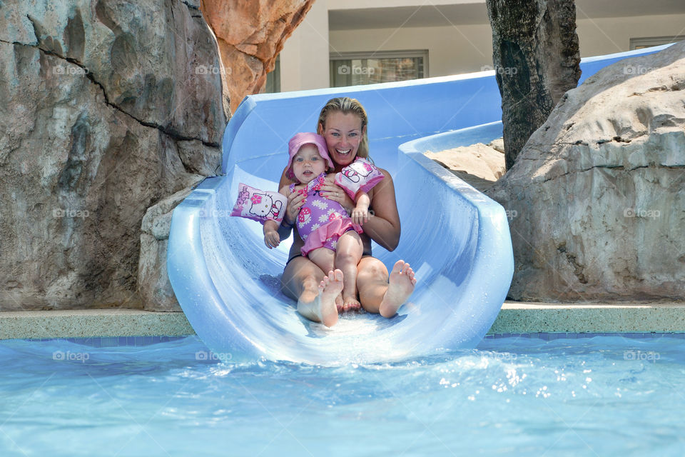 Woman with her baby enjoying the water slide