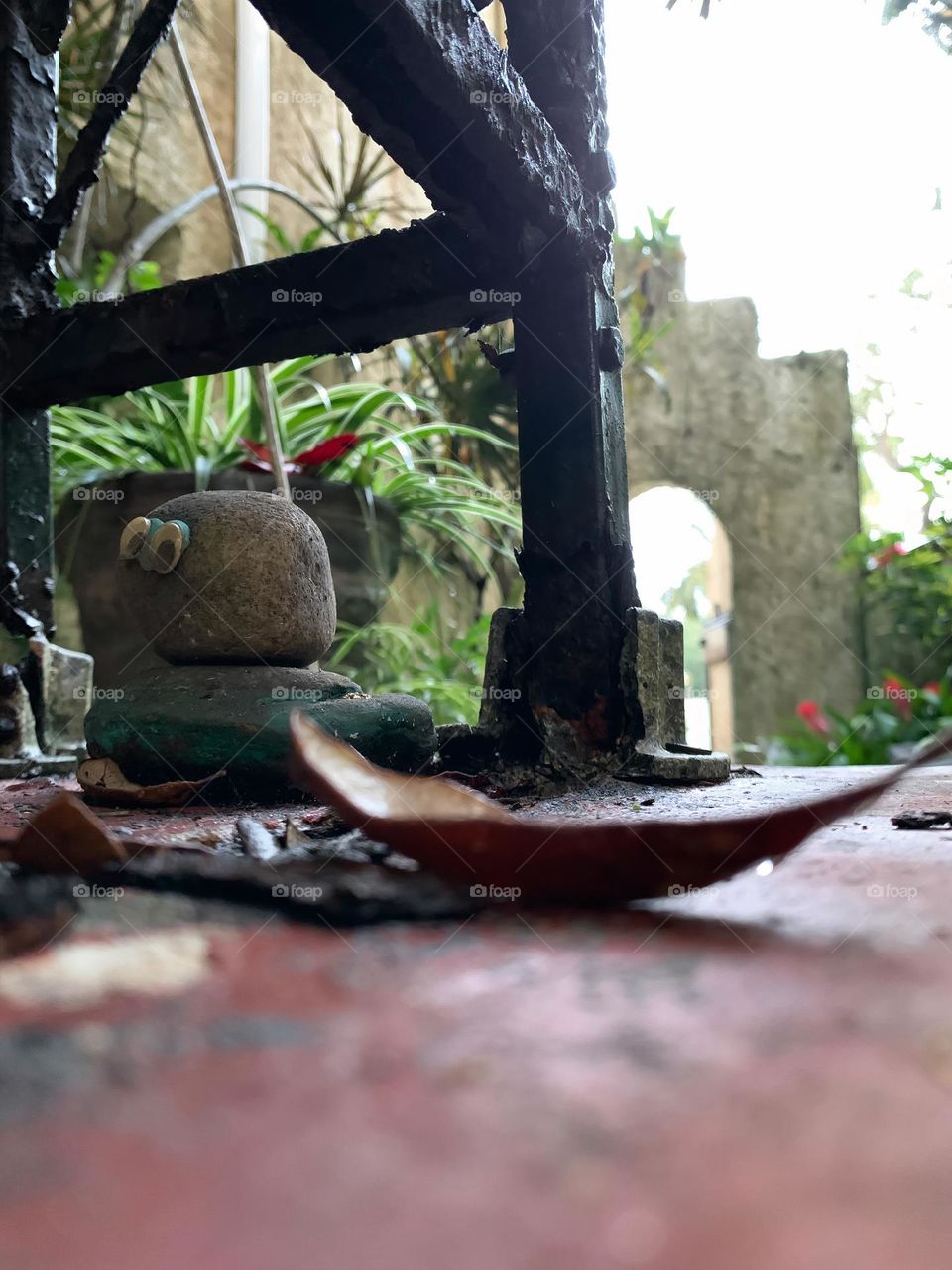 Architectural residence backyard with artifact or decoration with googly eyes and black frame on a backyard porch with antique Spanish style from the early 1900s.