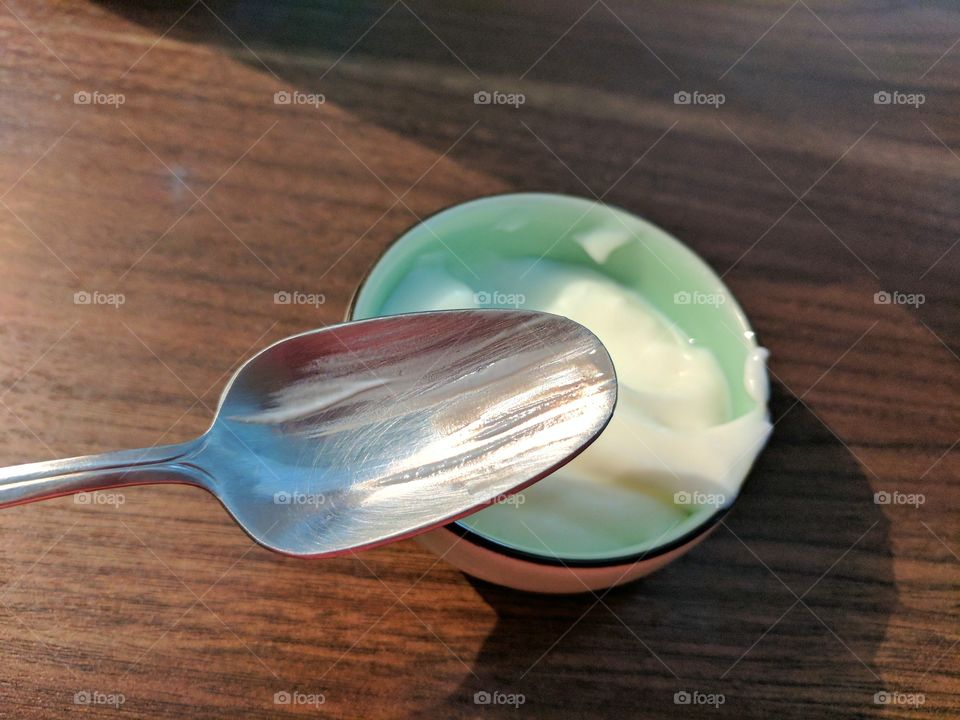 Partially eaten yoghurt with spoon