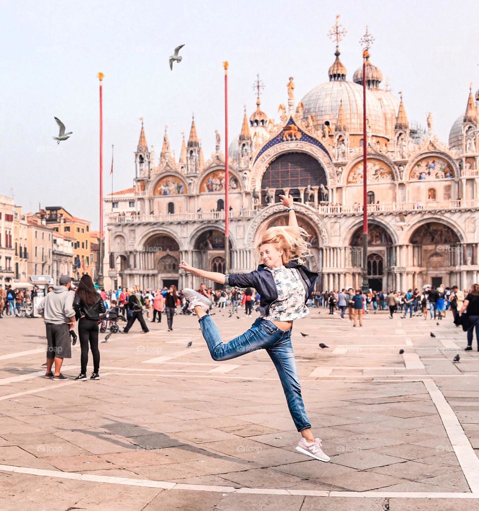 young woman jumping in the square in Venice