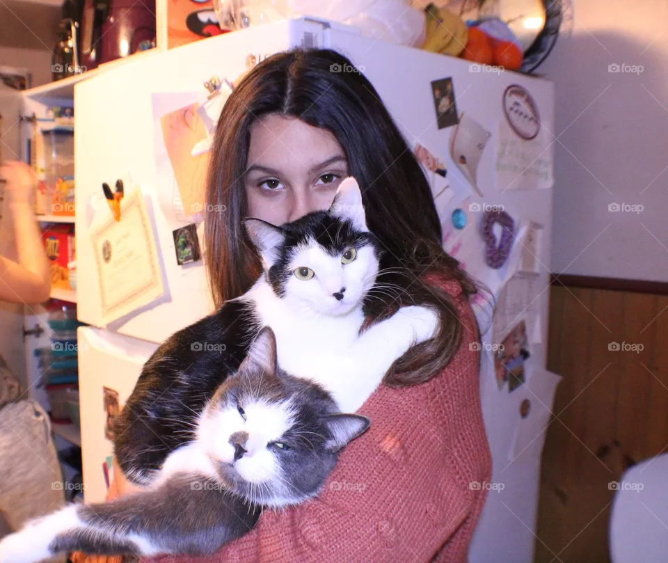 A Girl Holding Her two Cats
