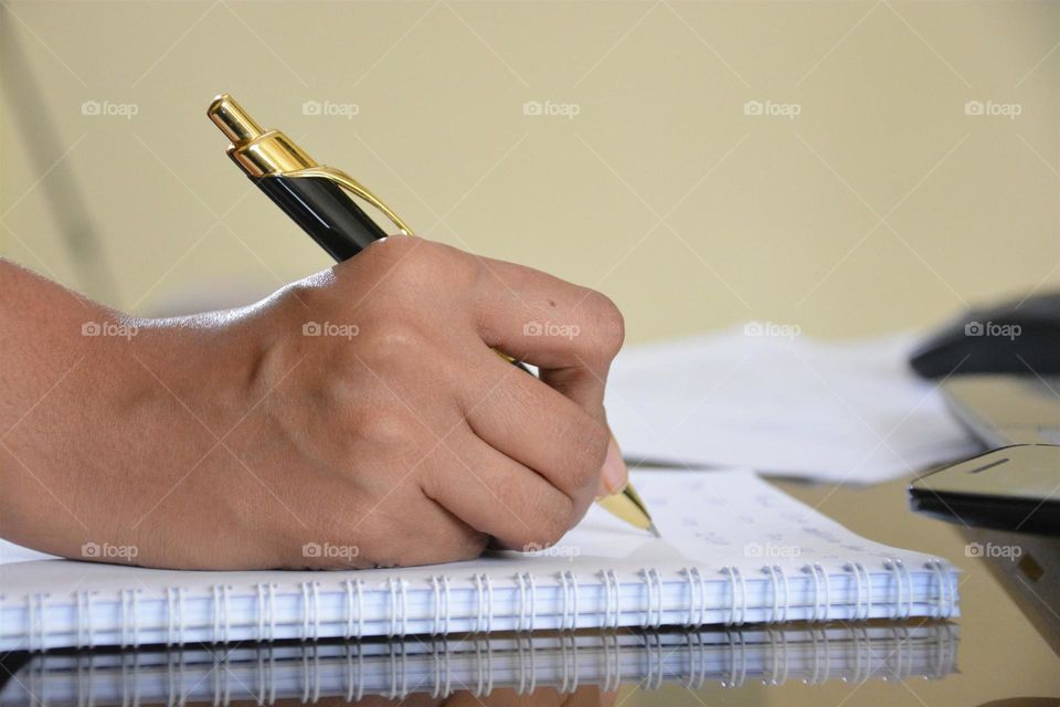 Person writing notes on spiral notebook