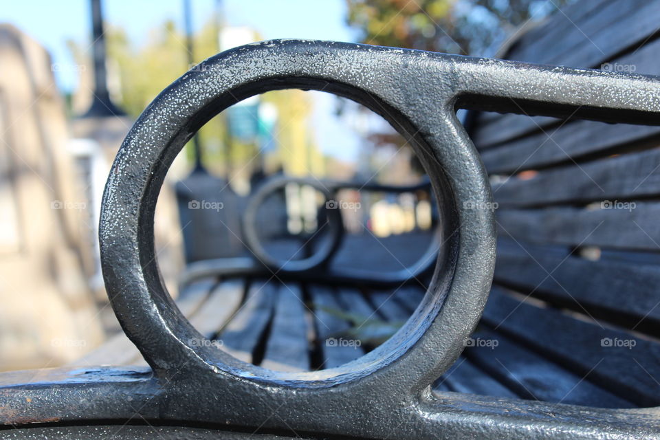 looking through the ring hole of a park bench in the city of Sacramento California on the Riverwalk.