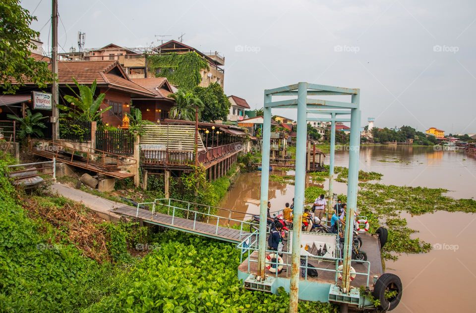 Thai People wait at a Pier for a ferry boat to cross the Chaophraya River in Ayutthaya Thailand Southeast Asia