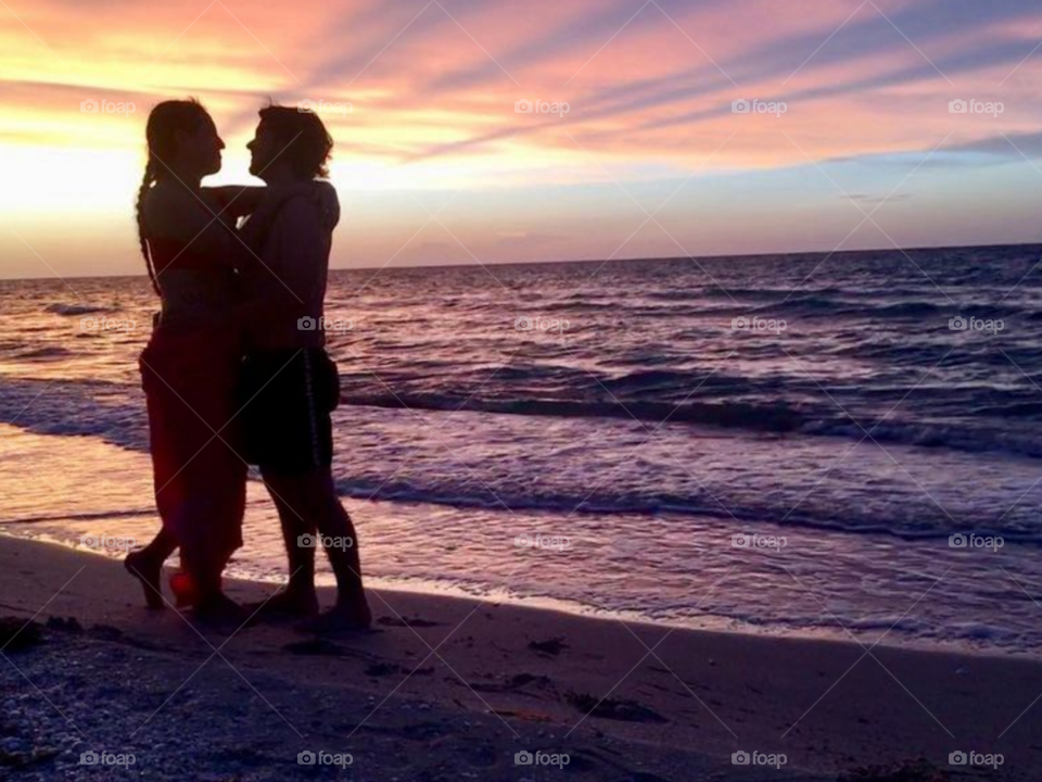 pareja en la playa al atardecer