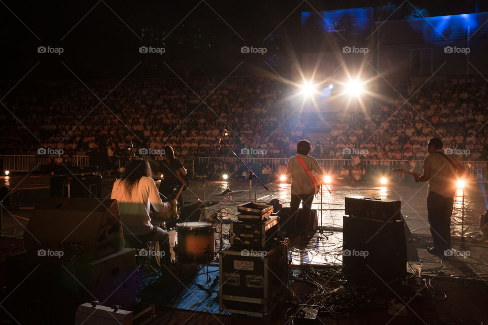 Concert in the stadium at night from behind the band