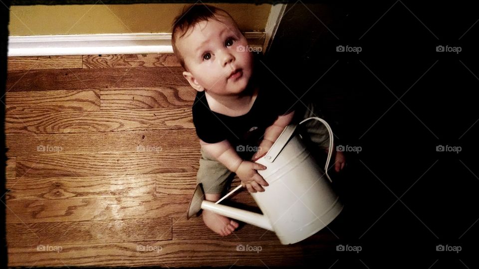 water can turned drum. little boy uses watering can to make music