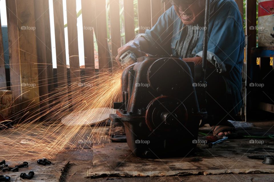 man working in workshop with grinder