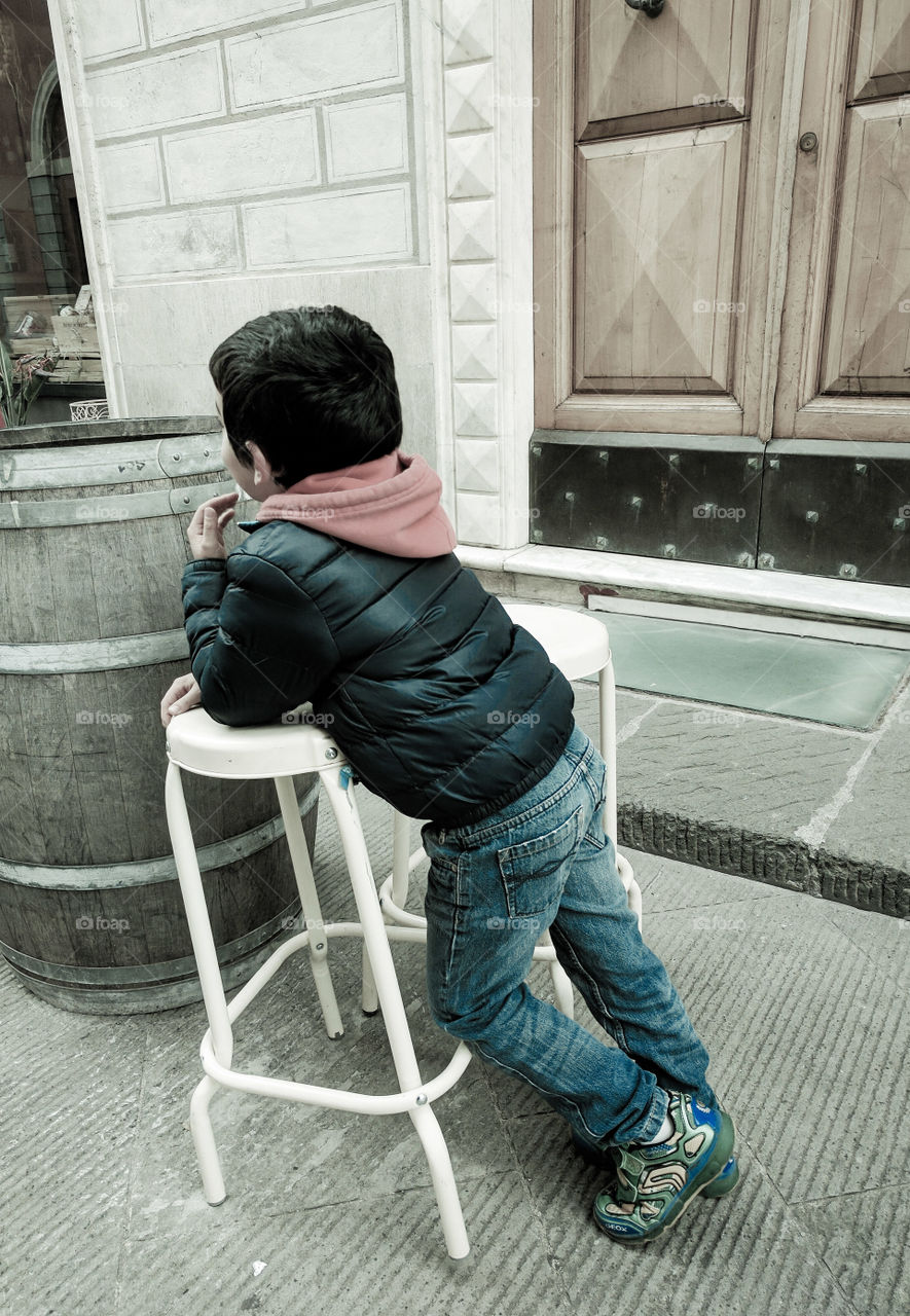 Child leaning on a stool watching Christmas lights