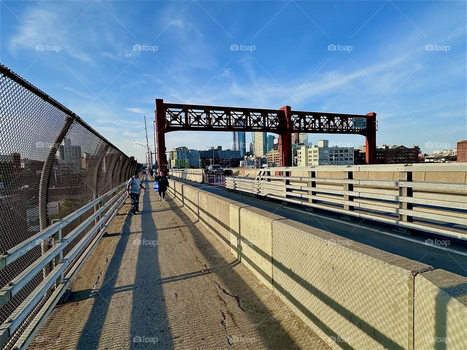 This is „Pulaski Bridge“ at „Newtown Creek“ that connects „Greenpoint“, Bklyn to LIC, Queens in the golden light of the evening sun. Dramatic shadows accentuate the streamlined essence of its design. 2024. Hypnotic Productions