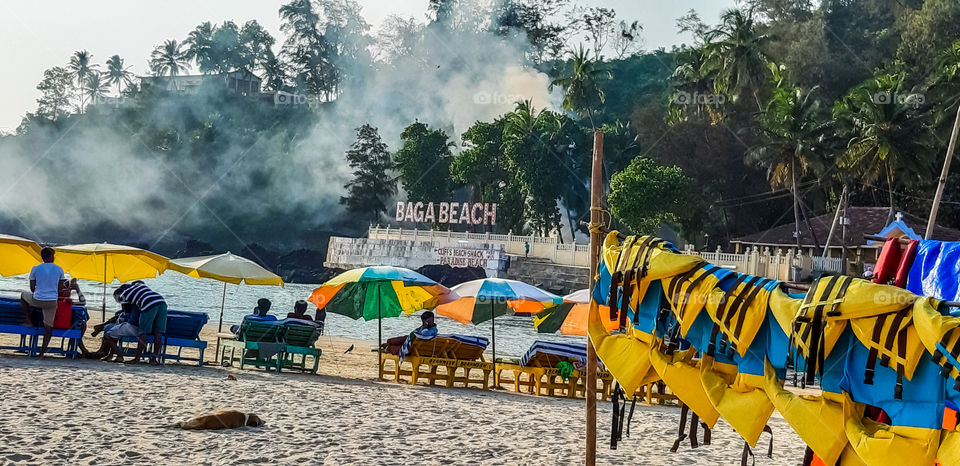 colourful beach - It is beach with colourful umbrellas and people relaxing on beach chair and enjoying summer holidays. surrounding nature is so colourful.