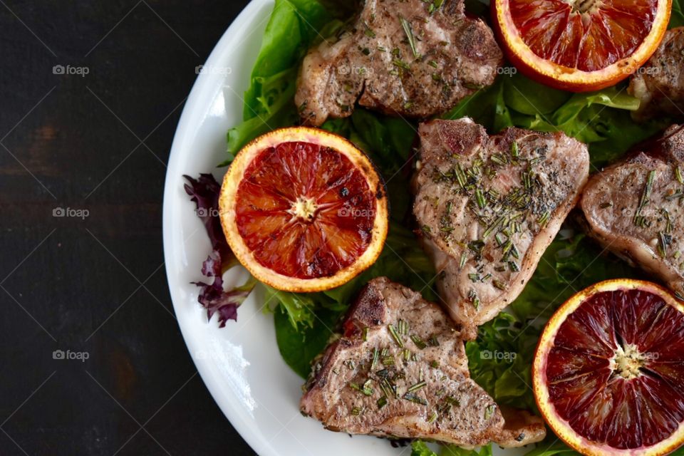 Grilled lamb loin chops and blood oranges on spring greens