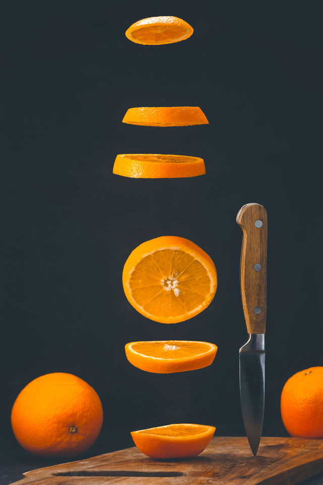 Flying Orange Cut Into Rings On Black Background