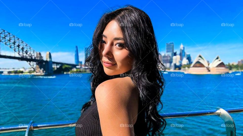 Portrait of a beautiful young woman by the lake in the middle of the city