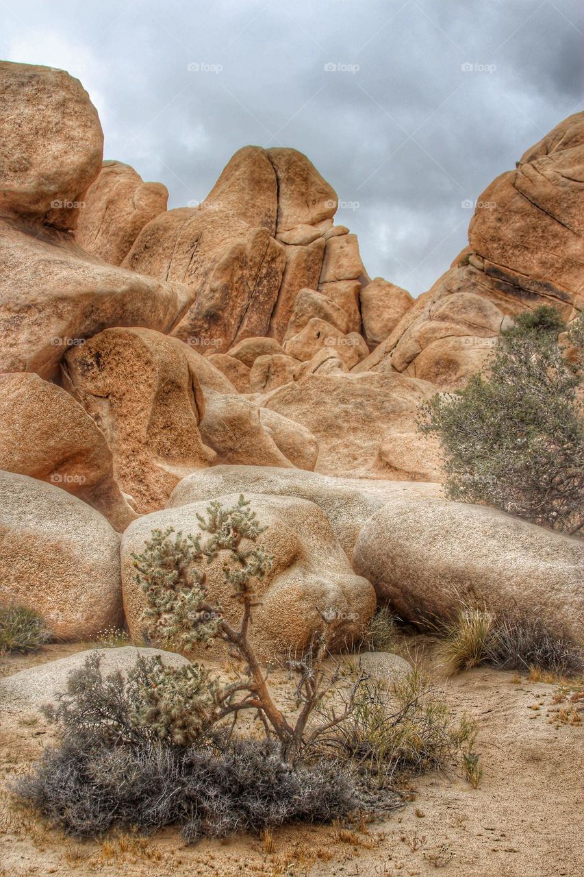 Stunningly beautiful rock formations at Joshua Tree National Park in California, with a cloud cover in the sky 