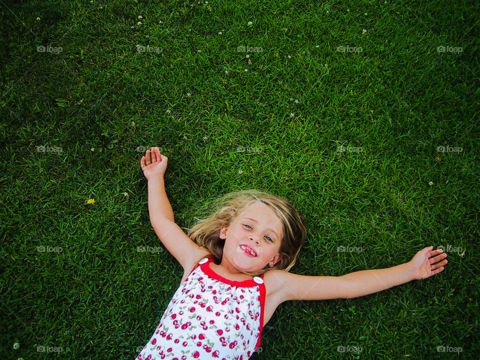 I Never Want to Grow-Up- girl lying in grass watching the clouds.