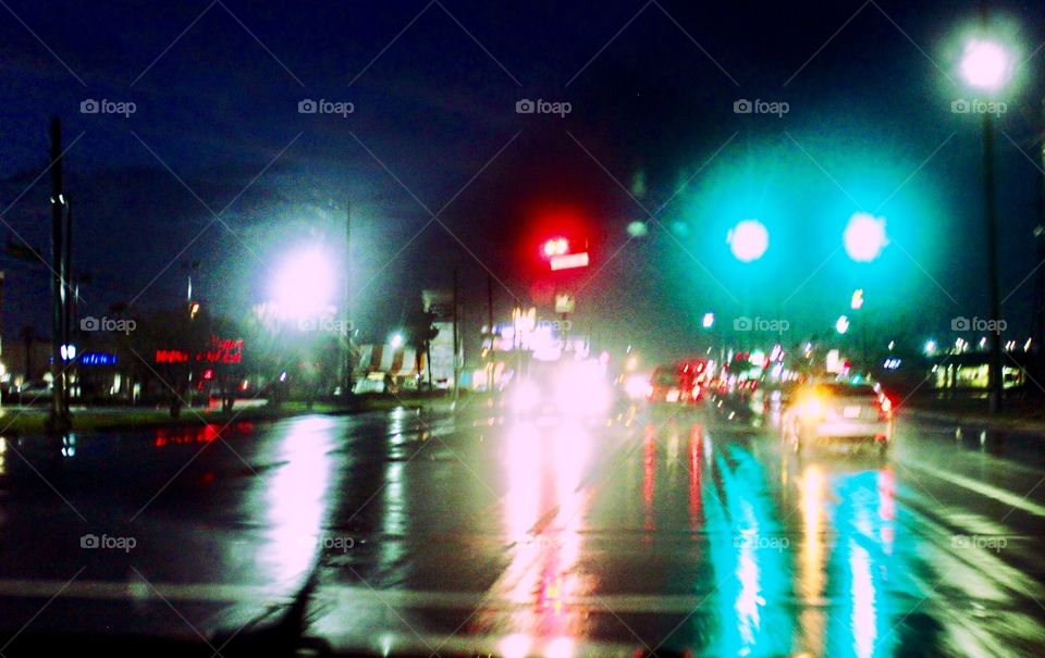 Traffic lights reflected on pavement.