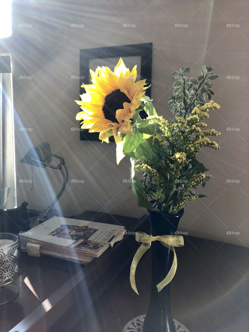 Sunflower bouquet on piano with sun rays coming in.