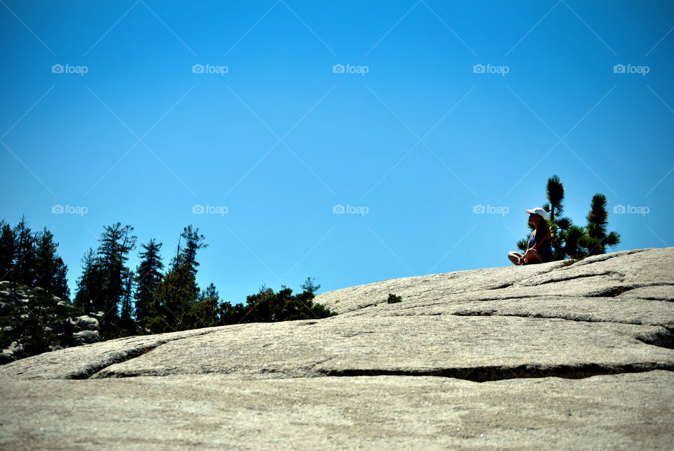 a girl sotting on top of a cliff
