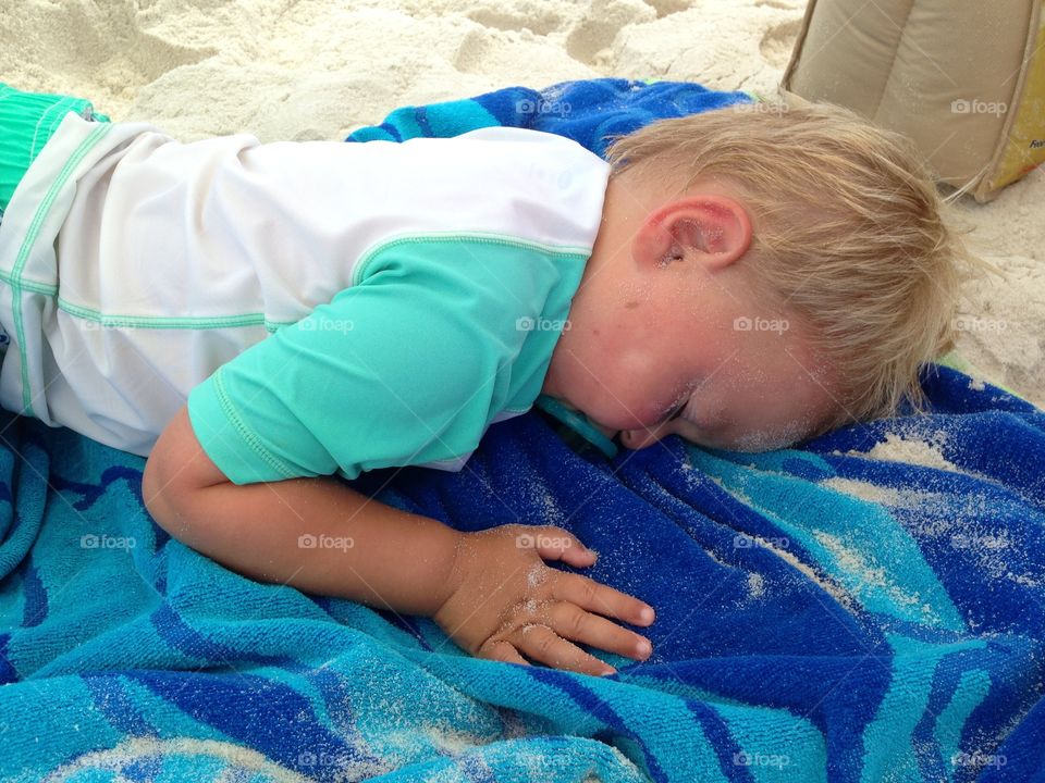 Cute boy sleeping on sand