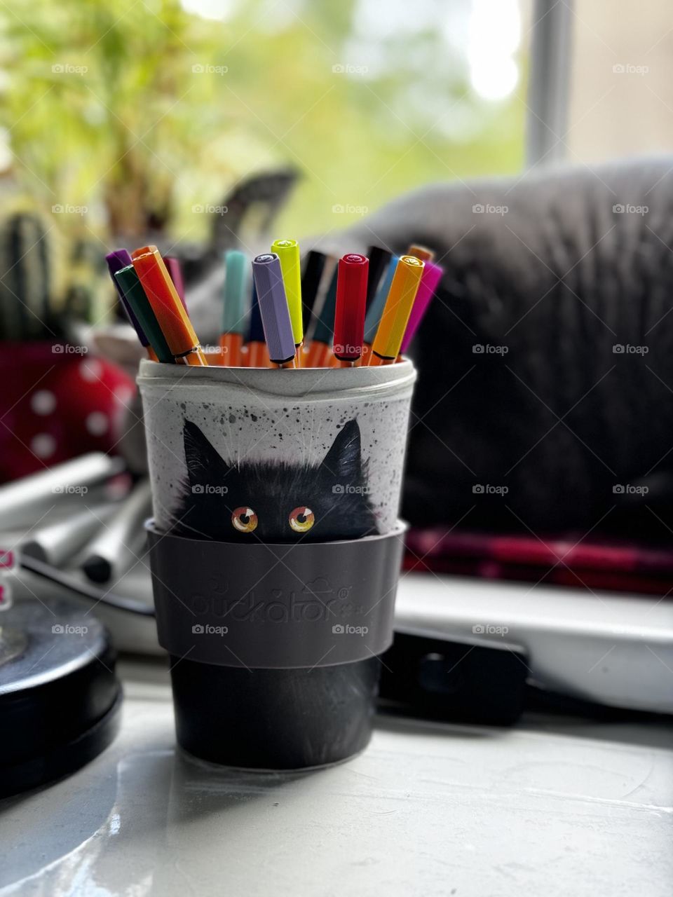 Colourful markers placed in the travel mug