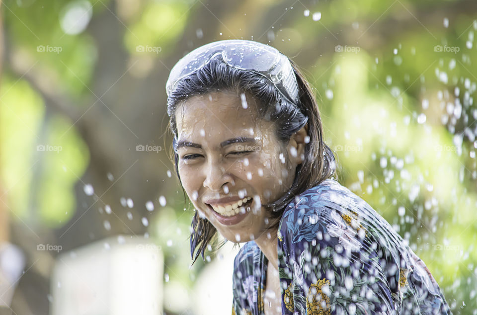 Asian woman play water in Songkran festival or Thai new year in Thailand.